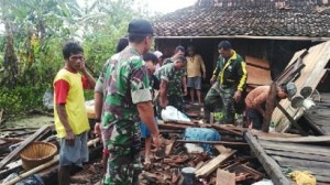 SEMANGAT : Danramil Mranggen Kapten Arm Utomo memimpin gotong royong bersama warga setelah terjadinya angin lesus, kemarin. (WAHIB PRIBADI/JAWA POS RADAR SEMARANG)