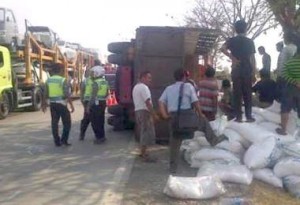 TERGULING: Truk bermuatan gula pasir yang terguling di jalur pantura Demak, Rabu (1/7) kemarin.